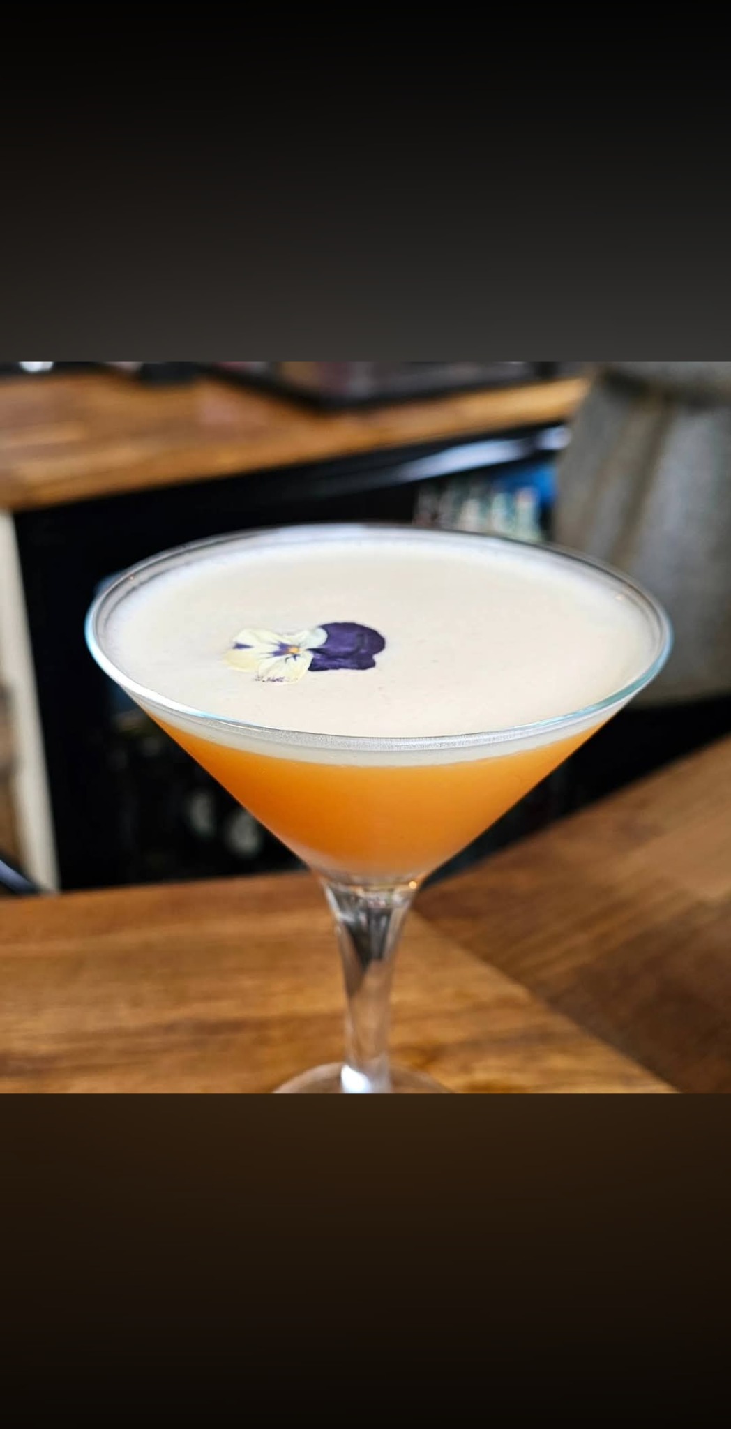 A freshly made cocktail finished with an edible flower at The White Oak bar