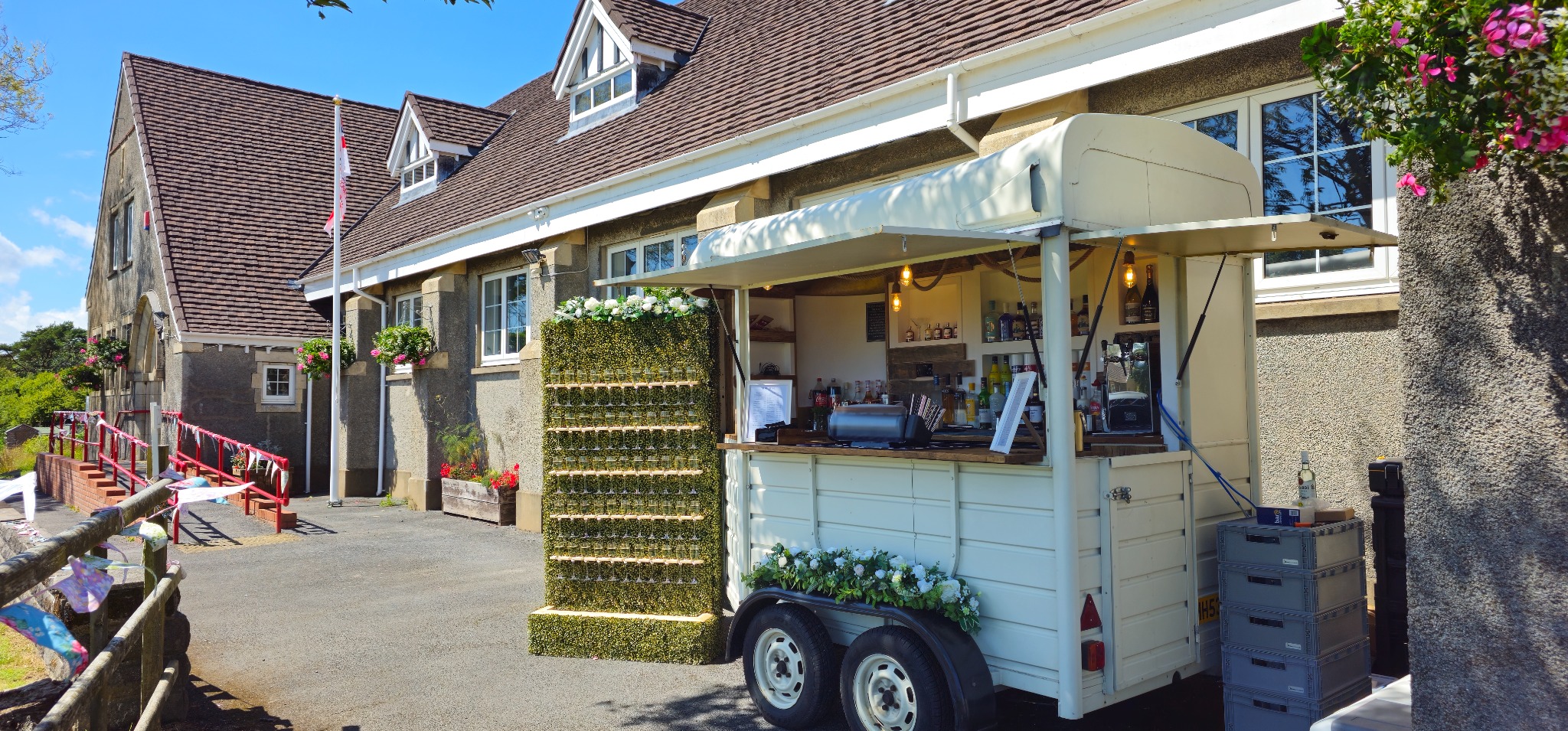 The White Oak horsebox bar set up beside its prosecco wall
